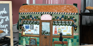 A photograph of a handbag featuring a bakery scene