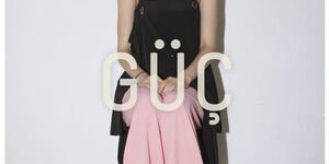 Image of a woman wearing a black shirt and a pink skirt.