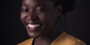 Image of a woman in a yellow top smiling.