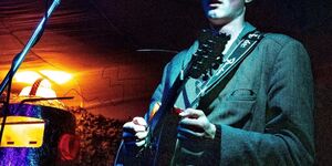 Image of a man playing the guitar.