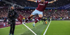 Image of a cameraman filming a football player.