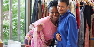 Two women at a stall smiling