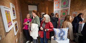 An image of a crowd looking at Gina's artwork.