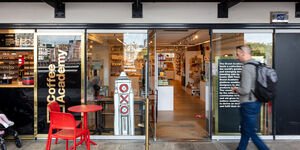 Image of someone walking past a shop.