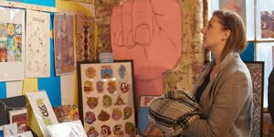 A woman browsing through illustrations.