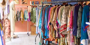 The interior of a shop with clothes hanging from rails