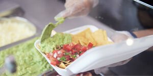 A white carton being filled with food