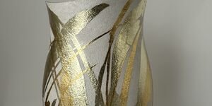 Image of a grey and gold ceramic vase.