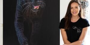 An image of Sophie Green sat next to her painting of a black panther.