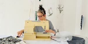 Image of artist Beatrice Mayfield working at a sewing machine.
