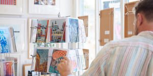 Photograph of a person looking at a rack of colourful cards