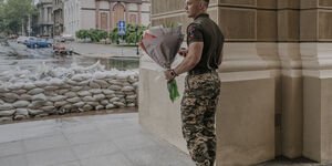 Image of a solider holding a bouquet of flowers.