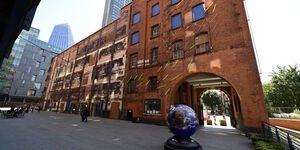 Landscape image of the globe in front of the archway.