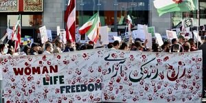 Image of a group of people holding up a banner at a protest.
