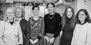 A black and white group photo of JeDeCo in their studio.