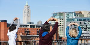 Three people exercising outside with Oxo Tower Wharf in background