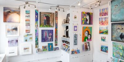 An image of a wall full of paintings.