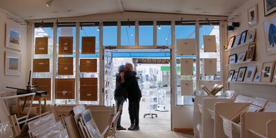 An image of two people hugging in the entrance of the gallery.