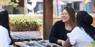 An image of three people sat together in Gabriel's Wharf.