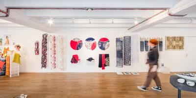 Image of someone walking past art on the wall in gallery@oxo.