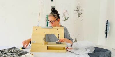 An image of Beatrice Mayfield working at her sewing machine.