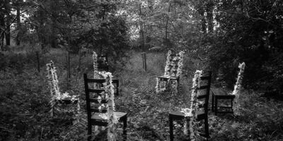 Artwork by Claire Malet, a black and white image of a group of chairs in a forest.
