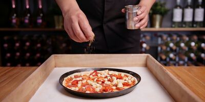Image of someone making a pizza at Gourmet Pizza Co.