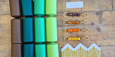 A set of green Christmas crackers and leather key fobs by Carreducker.