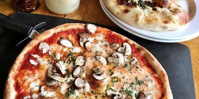 Image of a pizza on a wooden table.