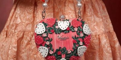 Image of a woman holding a pink handbag.