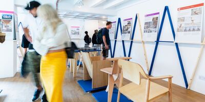 Image of people looking at woodwork in a gallery. 