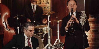 A group of musicians are photographed including a guitarist and clarinetist