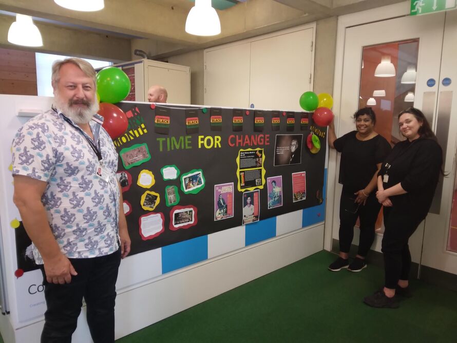 Keith, Hommie and Hayley by the Black History Month board