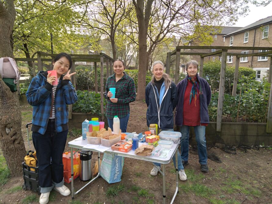 Gardeners smiling behind a table in the garden