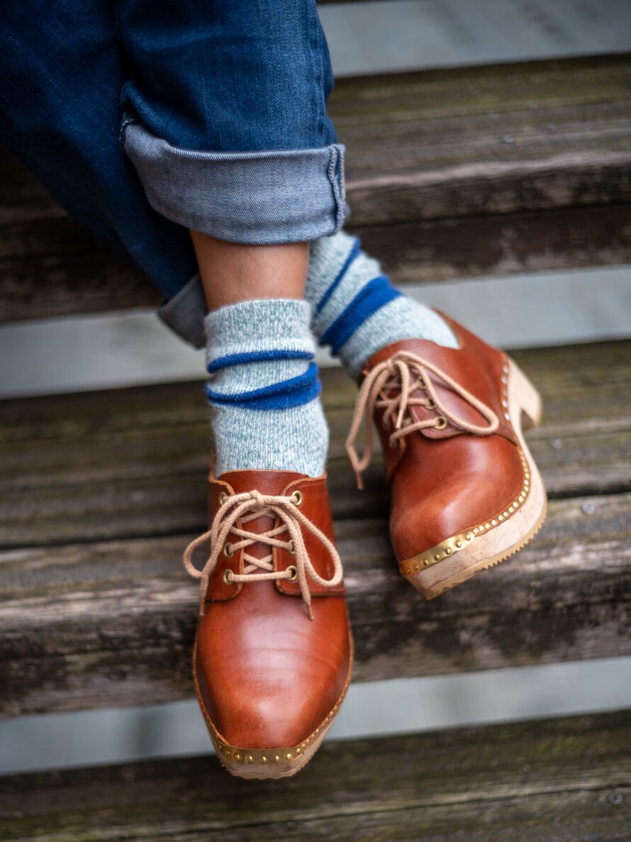 Image of someone wearing brown clogs.