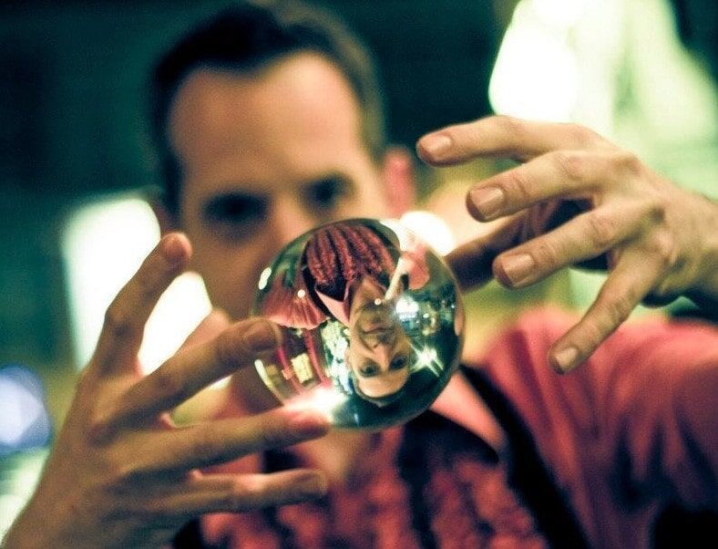 A man holds a crystal ball between his hands