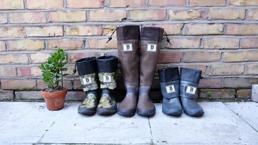 WBSJ, another brand, wellington boots lines up next to a brick wall. 