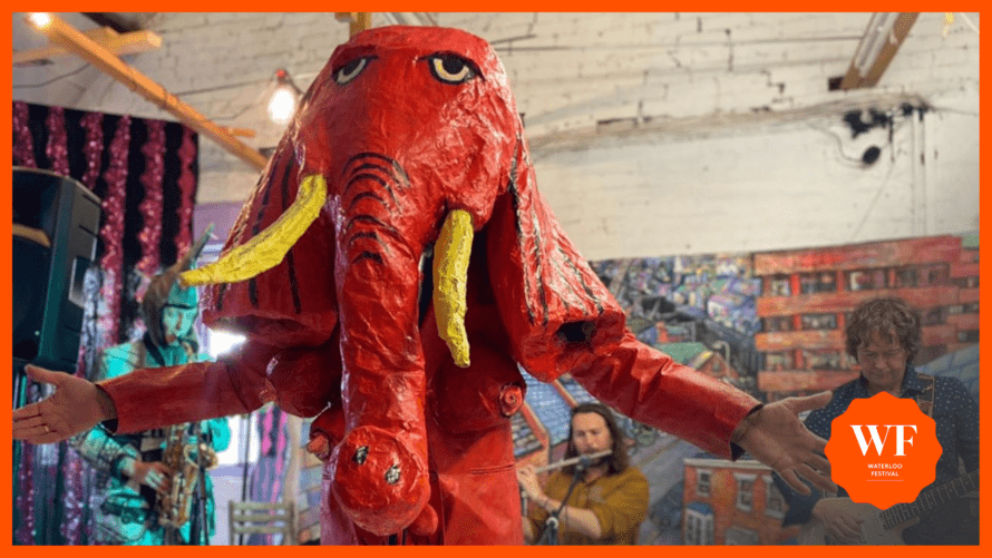 picture of a model of an elephant on stage with musical performers