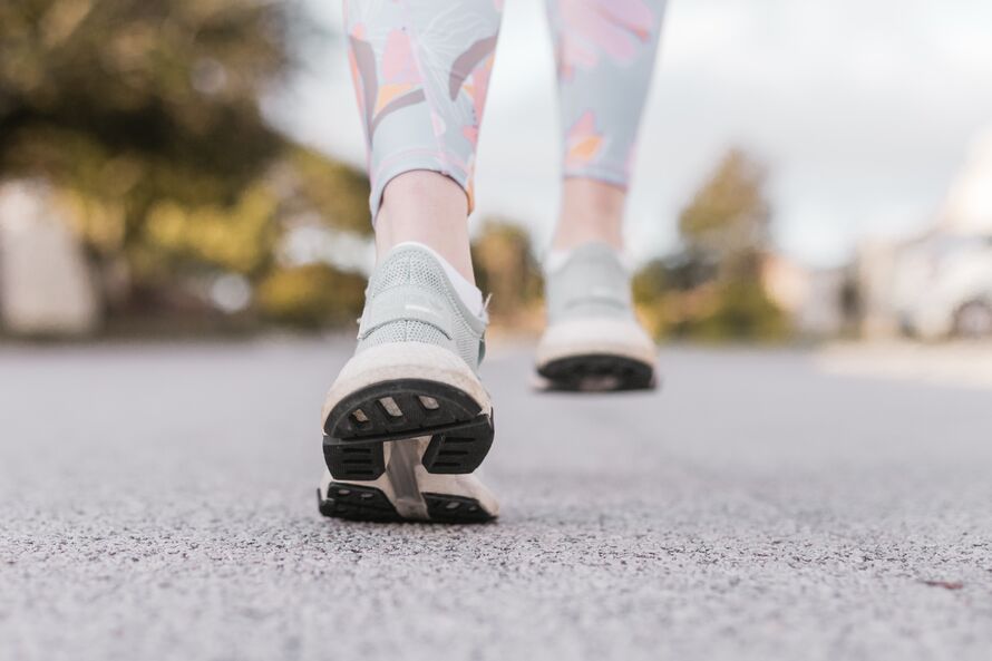 An image of a woman's feet in trainers walking.